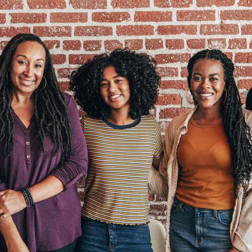 cheerful black people standing front red brick wall